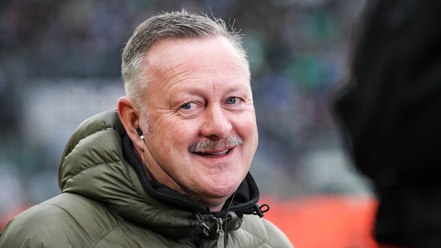 Roland Virkus steht im Rahmen des Bundesliga-Spiels von Borussia Mönchengladbach gegen Union Berlin am 23. April 2023 am Spielfeldrand im Borussia-Park und lächelt vor einem TV-Interview.