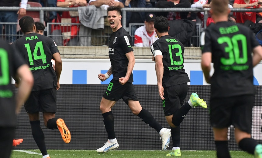 Julian Weigl (M.) jubelt nach seinem verwandelten Elfmeter für Borussia Mönchengladbach zum zwischenzeitlichen 1:1 beim VfB Stuttgart am 29. April 2023. Lars Stindl und Alassane Plea eilen zum Jubel herbei.