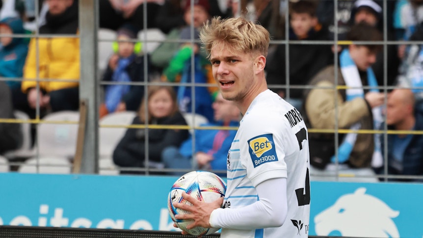 Leandro Morgalla hält beim Drittligaspiel von 1860 München gegen den VfL Osnabrück am 8. April 2023 den Ball zum Einwurf in der Hand.