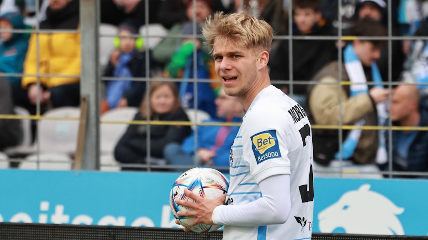 Leandro Morgalla hält beim Drittligaspiel von 1860 München gegen den VfL Osnabrück am 8. April 2023 den Ball zum Einwurf in der Hand.