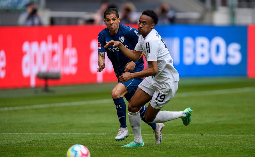 Den Ball im Blick. Nathan Ngoumou (r.) von Borussia Mönchengladbach und Cristian Gamboa vom VfL Bochum am 6. Mai 2023 im Laufduell um das Spielgerät.