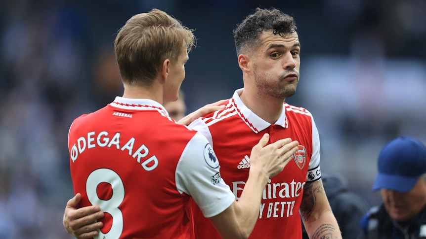 Ex-Gladbach-Kapitän und Arsenal-London-Star Granit Xhaka (r.) umarmt sichtlich erleichtert Team-Kollege Martin Odegaard (l.) nach dem Sieg im Premier-League-Duell (7. Mai 2023) bei Newcastle United. Xhaka pustet durch.