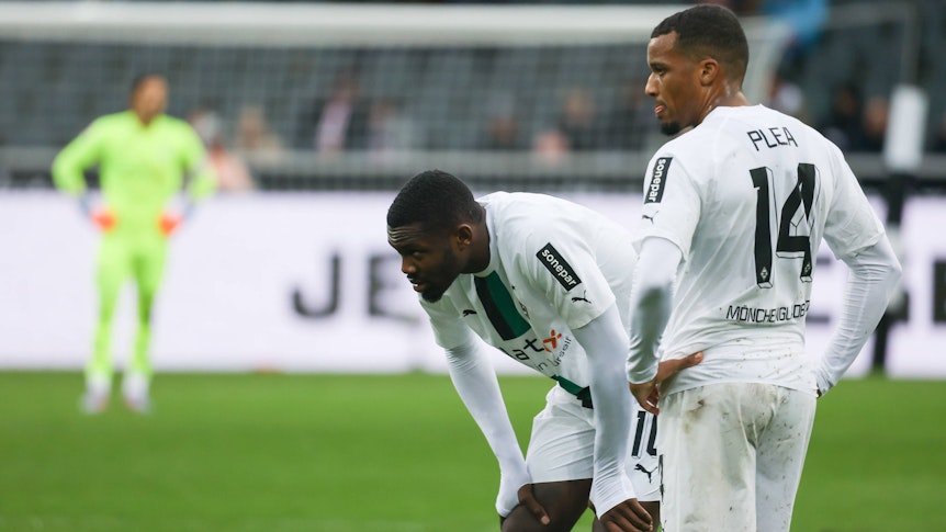 Die Gladbach-Stürmer Alassane Plea (r.) und Marcus Thuram, hier zu sehen am 14. Januar 2023 im Borussia-Park. Beide schauen unzufrieden zur Seite.