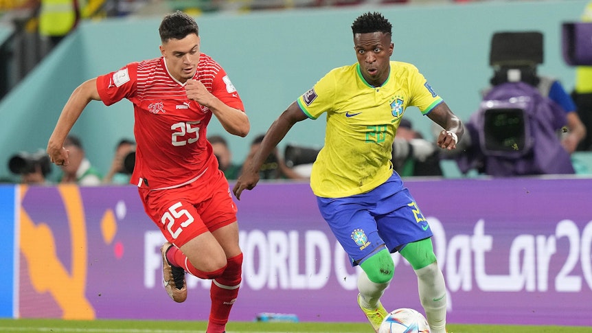 Fabian Rieder (l.) liefert sich beim WM-Spiel der Schweiz gegen Brasilien am 28. November 2022 ein Laufduell mit Vinicius Jr. von Real Madrid.