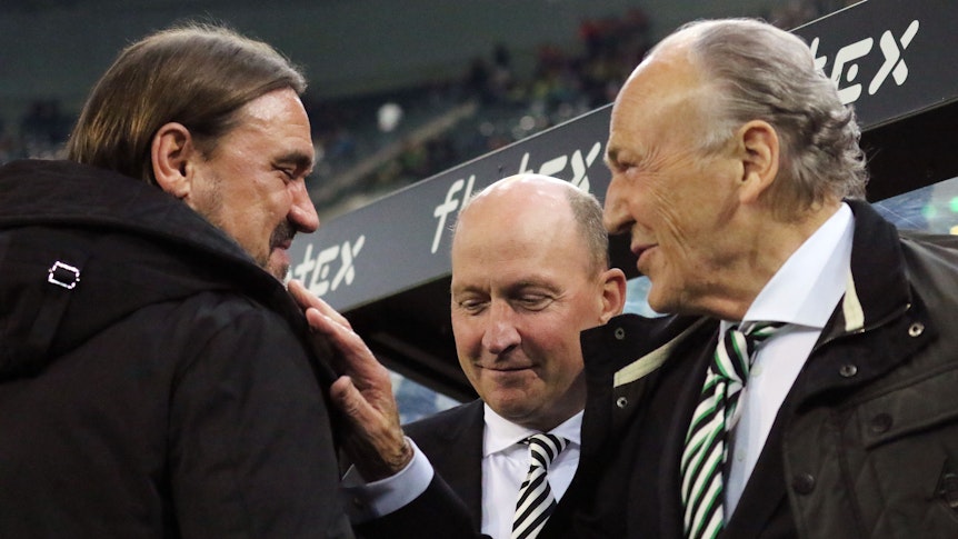 Gladbach-Präsident Rolf Königs (r.) im Gespräch mit Borussia-Trainer Daniel Farke (l.), zu sehen ist auch Finanzchef Stephan Schippers (M). Das Foto ist am 11. November 2022 im Borussia-Park entstanden. Königs lächelt und greift Farke an die Schulter.
