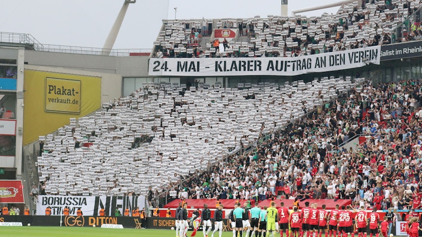 Die Fans von Borussia Mönchengladbach fordern ihren Klub vor dem Bundesliga-Auswärtsspiel bei Bayer Leverkusen (21. Mai 2023) auf, gegen den geplanten DFL-Anteilsverkauf zu stimmen. Auf Bannern steht „24. Mai – klarer Auftrag an den Verein“ und „Borussia stimmt Nein!“. Die Fans halten zahlreiche Schilder mit dem Wort „Nein“ hoch.