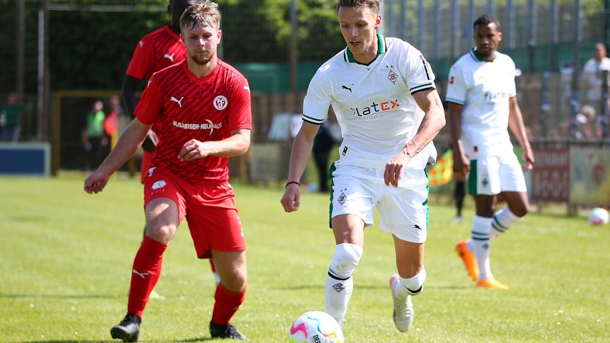 Borussia Mönchengladbach hat am Pfingstmontag (29. Mai 2023) 7:0 im Freundschaftsspiel beim FC Oberneuland gewonnen. Das Foto zeigt Fohlen-Profi Hannes Wolf im Zweikampf mit einem der Oberliga-Spieler.