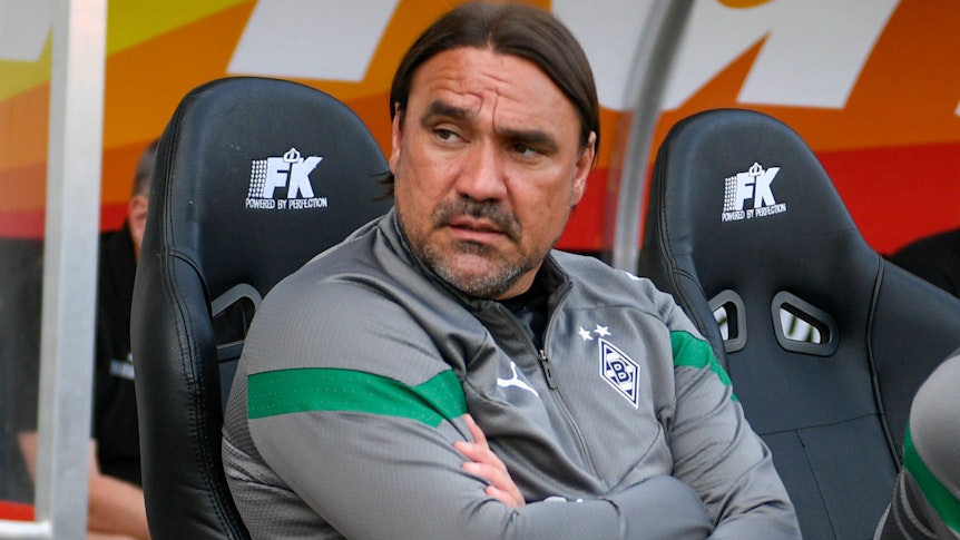 Daniel Farke in seinem letzten Spiel als Trainer von Fußball-Bundesligist Borussia Mönchengladbach. Das Bild zeigt den 46-Jährigen am 31. Mai 2023 während des Test-Kicks beim Hallescher FC. Farke hat die Arme verschränkt.