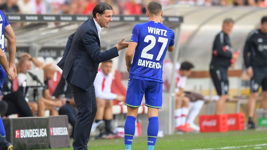Gerardo Seoane (l.) spricht am 19. September 2021 beim Bundesliga-Auswärtsspiel in Stuttgart in seiner Zeit von Bayer Leverkusen mit Florian Wirtz.