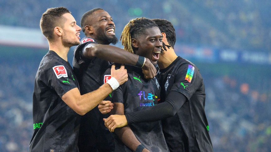 Der Gladbach-Profi Marcus Thuram (2.v.l.) jubelt gemeinsam mit Manu Koné (2.v.r.), Lars Stindl (r.) und Julian Weigl (l.) über einen Treffer. Hier zu sehen am 11. November 2022 im Borussia-Park während des Duells gegen Dortmund. Die Spieler umarmen sich.
