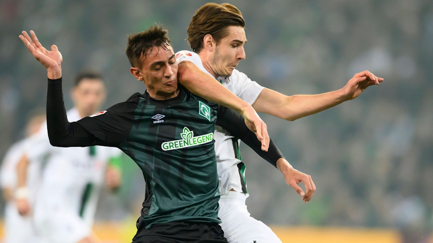Gladbach-Profi Florian Neuhaus (r.) im Zweikampf mit Fabio Chiarodia (l.) von Werder Bremen. Das Foto stammt vom 17. März 2023. Die beiden haben den Blick auf den Ball gerichtet.