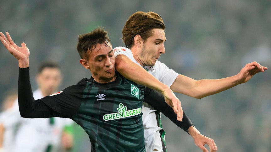 Gladbach-Profi Florian Neuhaus (r.) im Zweikampf mit Fabio Chiarodia (l.) von Werder Bremen. Das Foto stammt vom 17. März 2023. Die beiden haben den Blick auf den Ball gerichtet.