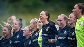 Die Spielerinnen von Borussia Mönchengladbach feiern den Aufstieg in die 2. Bundesliga, hier am 18. Juni 2023 in Elversberg zu sehen. Die Frauen umarmen sich und jubeln.