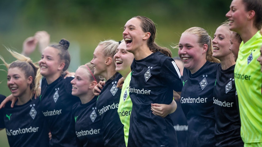 Die Spielerinnen von Borussia Mönchengladbach feiern den Aufstieg in die 2. Bundesliga, hier am 18. Juni 2023 in Elversberg zu sehen. Die Frauen umarmen sich und jubeln.