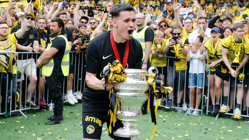 Da ist das Ding! Fabian Rieder von Young Boys Bern, hier zu sehem am 4. Juni 2023 in Wankdorf, feiert mit den Fans den Pokalgewinn. Rieder hält den Pokal in seinen Händen und schreit seine Freude heraus.