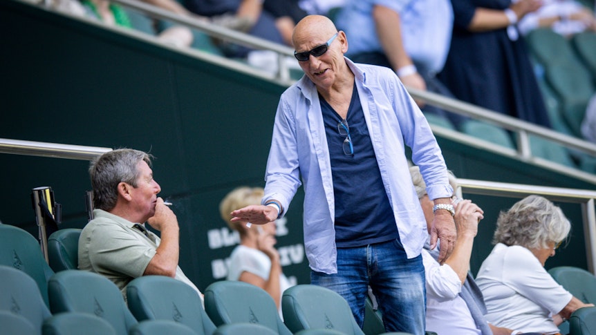 Wolfgang Kleff, Torwart-Legende von Borussia Mönchengladbach, begrüßt auf der Tribüne im Borussia-Park den bis dato letzten Titel-Trainer im Fohlen-Stall, Bernd Krauss. Das Foto zeigt die beiden am 23. Juli 2022. Kleff trägt eine Sonnenbrille. Krauss zieht an einer Zigarette.