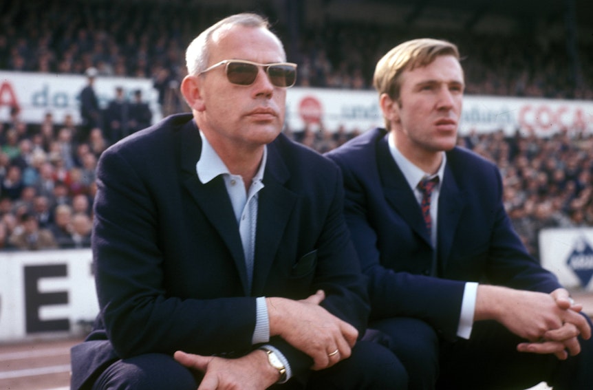 Hennes Weisweiler (l.), verstorbener Legenden-Trainer von Borussia Mönchengladbach, hier gemeinsam mit Fohlen-Spielmacher Günter Netzer. Das Foto ist am 1. September 1968 entstanden. Die beiden sitzen auf der Bank und schauen auf das Spielfeld.
