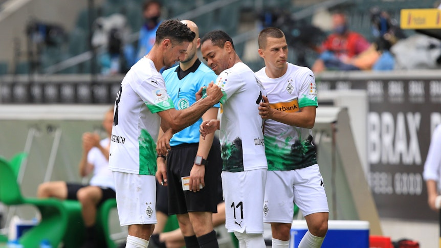 Lars Stindl (l.) überreicht Raffael (M.) in dessen letztem Spiel für Borussia Mönchengladbach gegen Hertha BSC am 27. Juni 2020 die Kapitänsbinde.