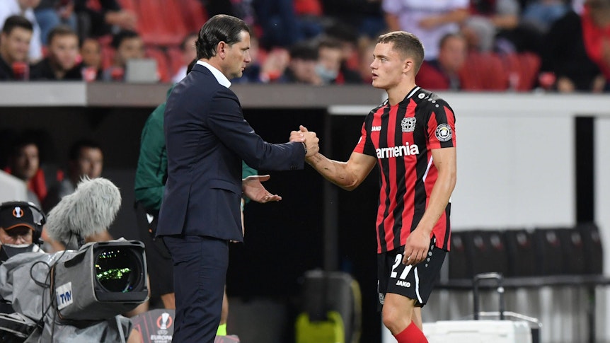 Gerardo Seoane (l.) gibt Florian Wirtz im Rahmen eines Spiels von Bayer Leverkusen am 16. September 2021 die Hand.