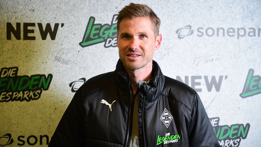 Oliver Kirch, hier am 17. Dezember 2022 im Borussia-Park zu sehen, übernimmt den U19-Trainerjob bei Fußball-Bundesligist Borussia Mönchengladbach. Kirch steht vor einer Fotowand, auf der Legenden des Parks zu lesen ist.