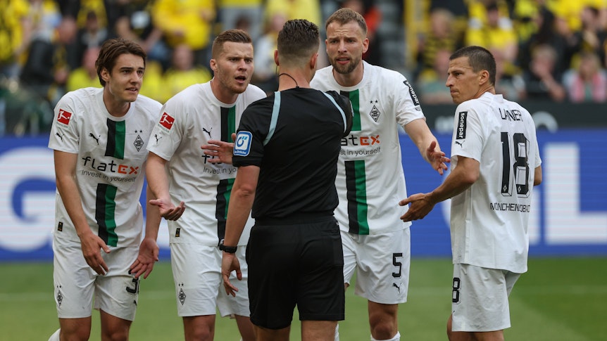Spieler von Borussia Mönchengladbach beschweren sich im Spiel bei Borussia Dortmund am 13. Mai 2023 beim Schiedsrichter Daniel Schlager.