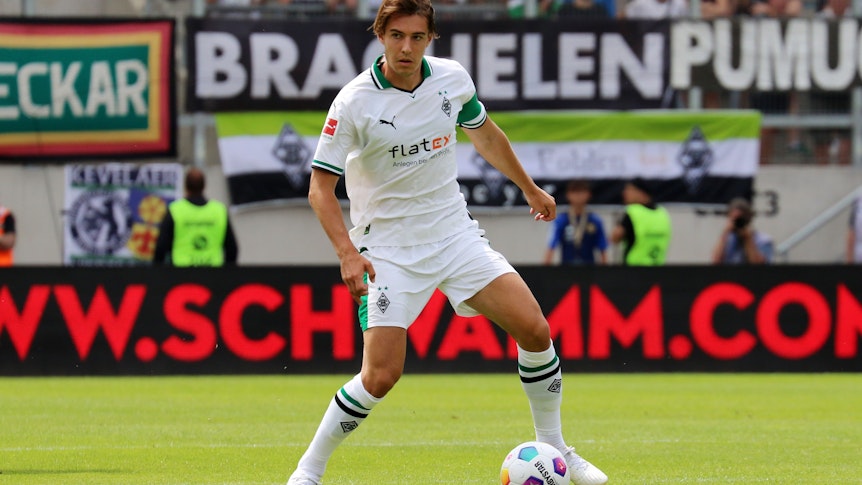 Florian Neuhaus mit der Kapitänsbinde am linken Arm. Das Foto zeigt den Mittelfeldspieler von Borussia Mönchengladbach am 22. Juli 2023 in Saarbrücken. Er hat den Ball vor sich auf dem Spielfeld liegen.
