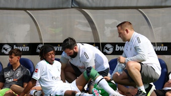 Yvandro Borges Sanches wird während des Testspiels von Borussia Mönchengladbach beim 1. FC Saarbrücken am 22. Juli 2023 am Spielfeldrand behandelt. Sein linkes Knie ist bandagiert.