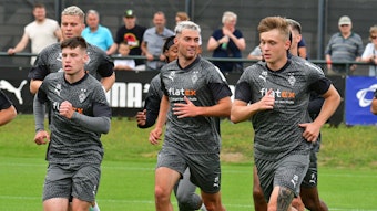 Die Spieler von Borussia Mönchengladbach um Joe Scally (Nummer 29) laufen am 17. Juli 2023 eine Runde über den Trainingsplatz am Borussia-Park.