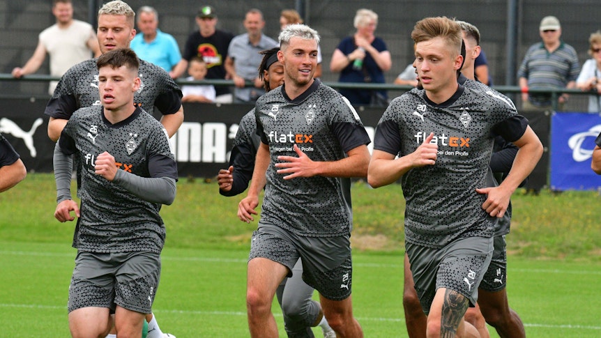 Die Spieler von Borussia Mönchengladbach um Joe Scally (Nummer 29) laufen am 17. Juli 2023 eine Runde über den Trainingsplatz am Borussia-Park.