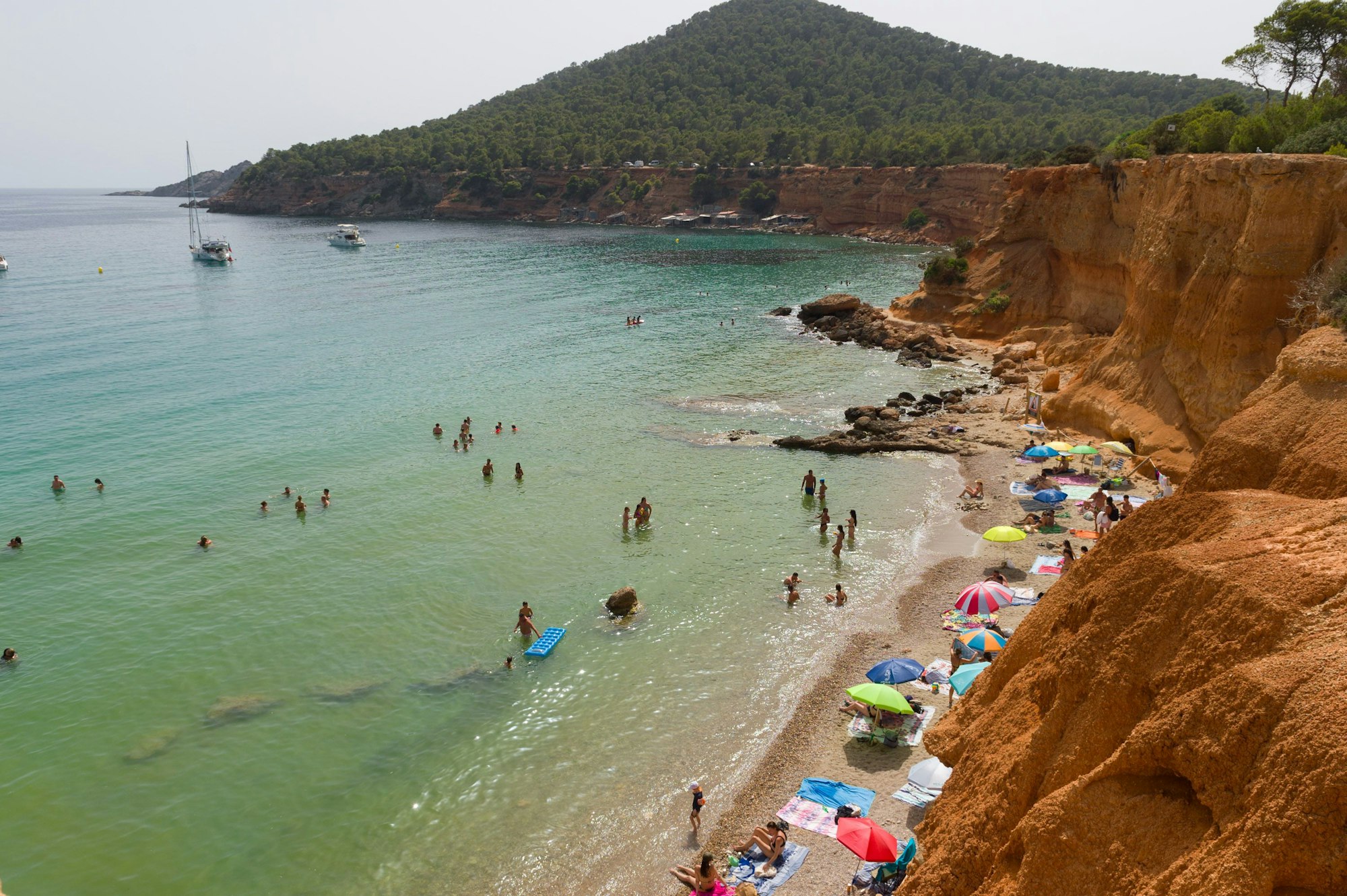 Menschen genießen einen Tag am Strand Es Bol Nou auf Ibiza, hier im Juli 2023.
