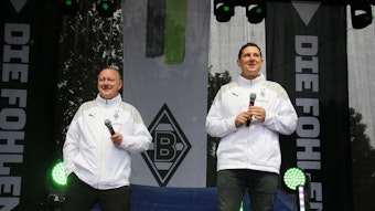 Manager Roland Virkus (l.) und Sportdirektor Nils Schmadtke (r.), hier zu sehen bei der Saisoneröffnung (6. August 2023) von Fußball-Bundesligist Borussia Mönchengladbach. Die beiden stehen auf einer Bühne und halten jeweils ein Mikrofon in ihren Händen.