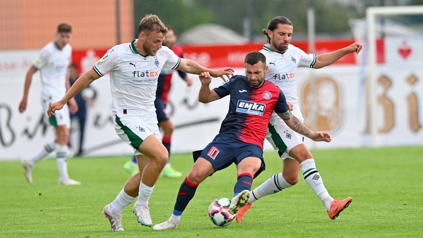 Borussia Mönchengladbach hat am Samstag (5. August 2023) 2:3 beim Wuppertaler SV in der Regionalliga West verloren. Das Foto zeigt Mika Schroers (l.) und Julian Korb (r.) im Duell mit Wuppertals Noah Raphael Andreas (Mitte).