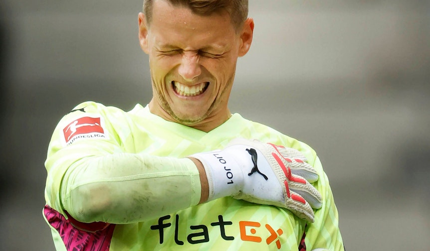 Gladbach-Torwart Jonas Omlin, hier zu sehen am 5. August 2023 im Borussia-Park, hat eine Schulterverletzung. Der Schweizer Nationalspieler droht für den Saisonauftakt auszufallen. Omlin hat sichtlich Schmerzen und fasst sich an die linke Schulter.