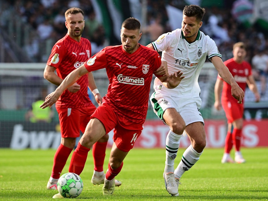 Alexander Bannink vom Tus Bersenbrück im Zweikampf mit Julian Weigl von Borussia Mönchengladbach beim DFB-Pokalspiel am 11. August 2023.