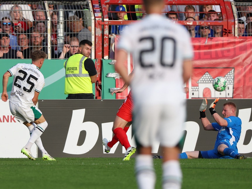Gladbachs Torschütze Robin Hack (l) erzielt den Treffer zum 0:6 gegen Bersenbrücks Torwart Nils Böhmann (r).