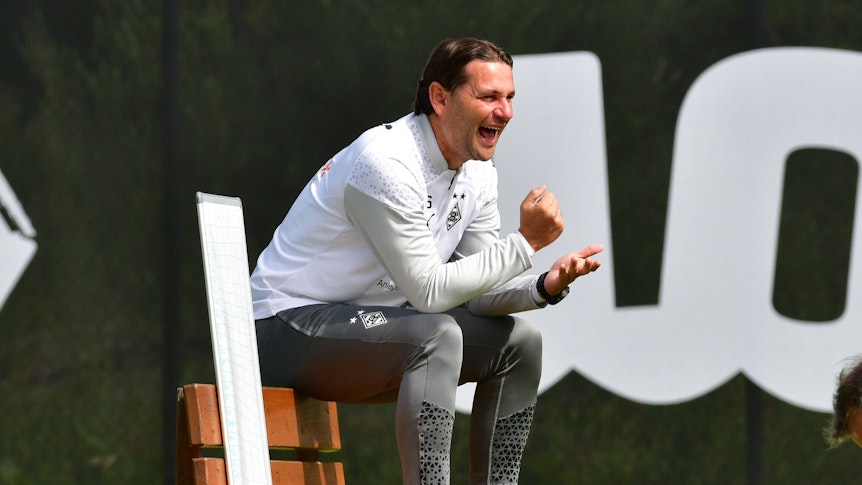 Gerardo Seoane sitzt im Trainingslager am 27. August auf einer Bank und lacht.