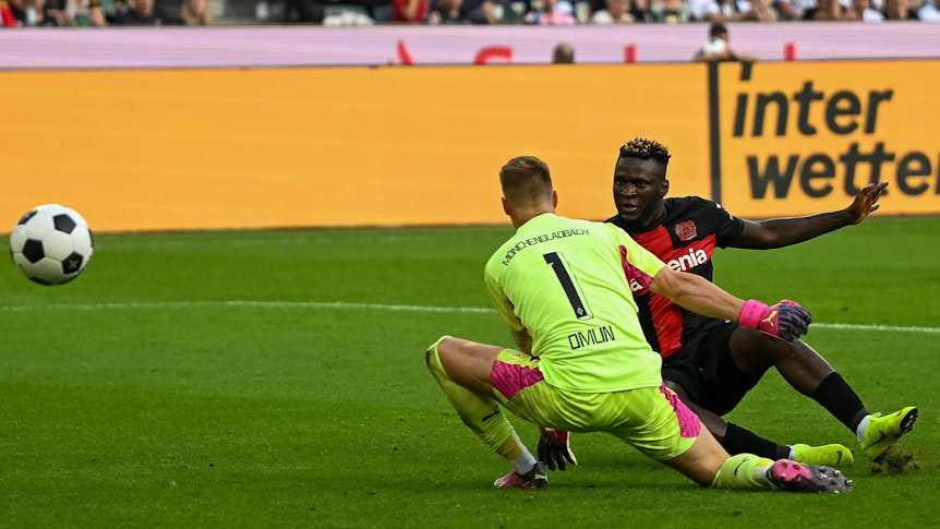 Victor Boniface (r.) trifft am 26. August 2023 zum zwischenzeitlichen 3:0 für Bayer Leverkusen gegen Borussia Mönchengladbach, Torwart Jonas Omlin ist machtlos.