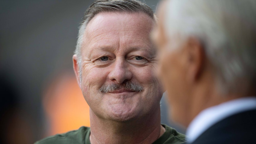 Roland Virkus grinst am 26. August 2023 und schaut in die Richtung von Rainer bonhof.