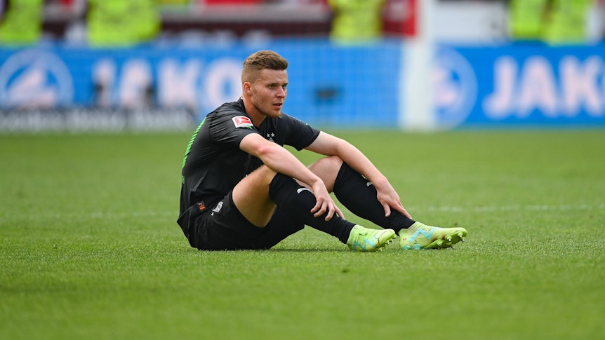 Nico Elvedi sitzt nach dem Bundesliga-Spiel von Borussia Mönchengladbach beim VfB Stuttgart am 29. April 2023 auf dem Rasen.