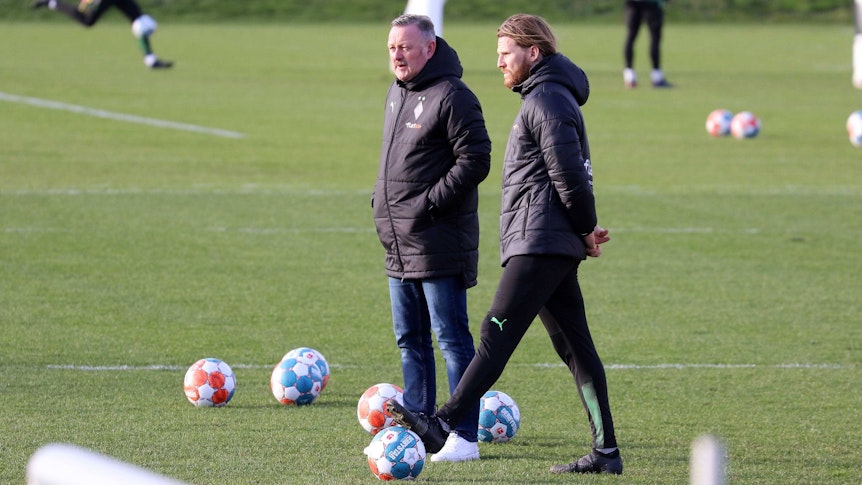 Roland Virkus (l.) und Eugen Polanski beobachten eine Trainings-Einheit am 15. Februar 2022.