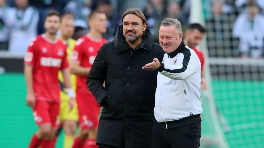 Daniel Farke (l.) und Roland Virkus stehen nach dem Derbysieg gegen den 1. FC Köln am 9. Oktober 2022 zufrieden auf dem Rasen.
