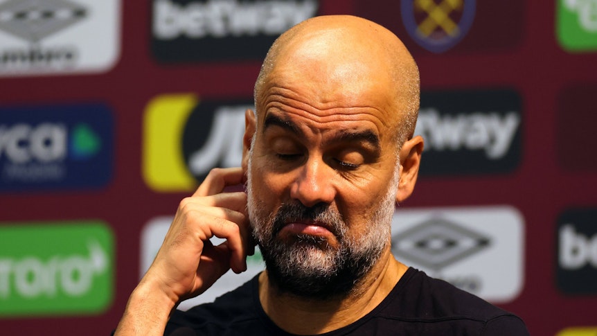 Pep Guardiola kratzt sich bei einer Pressekonferenz am 16. September 2023 am rechten Ohr.