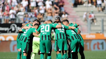 Die Spieler von Borussia Mönchengladbach bilden einen Kreis vor dem Spiel.