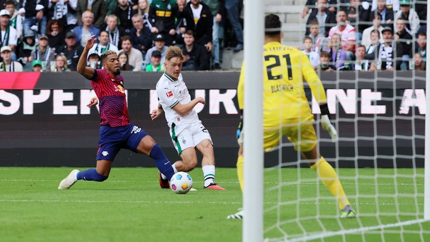 Luca Netz (M.) spielt einen Ball flach in den Strafraum von RB Leipzig.
