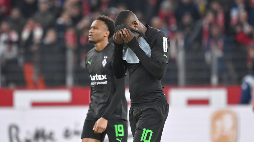 Marcus Thuram hält sich das Trikot vor das Gesicht.