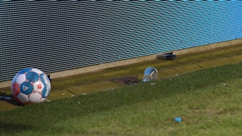 Zwei Bierbecher liegen im Bochumer Ruhrstadion neben einem Ball.
