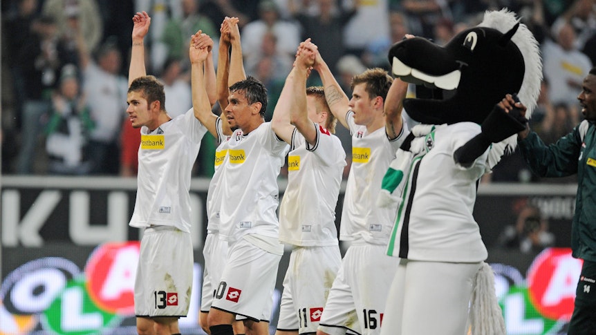 Spieler von Borussia Mönchengladbach feiern einen Sieg gegen den VfL Bochum mit den Fans vor der Nordkurve.