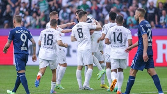 Gladbacher Spieler laufen zum Torschützen Hofmann und umarmen ihn. Zwei Bochumer Spieler laufen geknickt an ihnen vorbei.