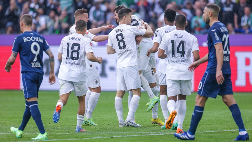 Gladbacher Spieler laufen zum Torschützen Hofmann und umarmen ihn. Zwei Bochumer Spieler laufen geknickt an ihnen vorbei.