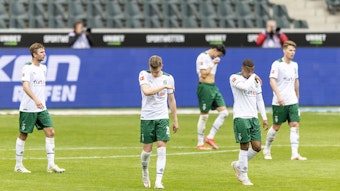 Spieler von Borussia Mönchengladbach verlassen enttäuscht das Spielfeld.